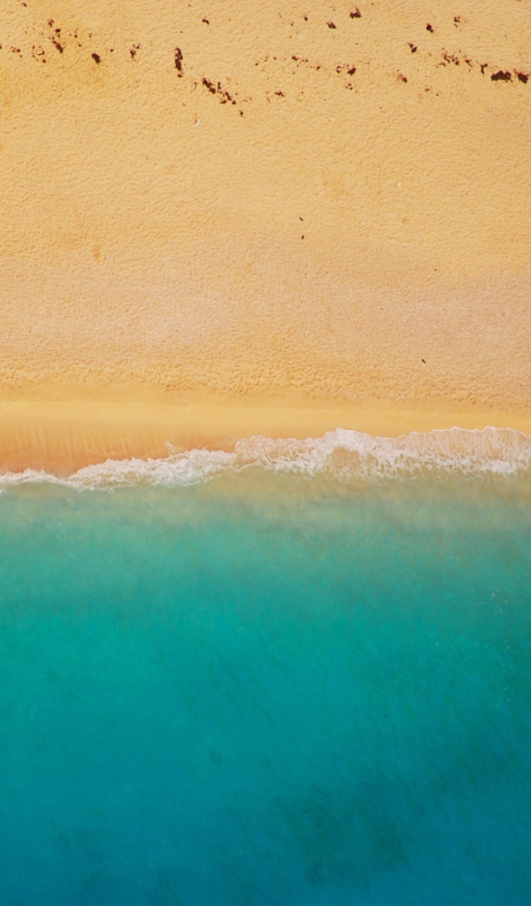 Желтый песок соединяется с голубой водой 