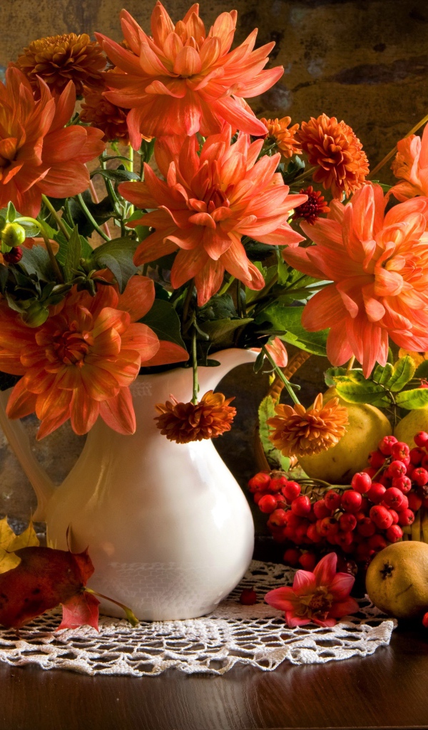 Букет георгин в вазе на столе с грушами и ягодами рябины