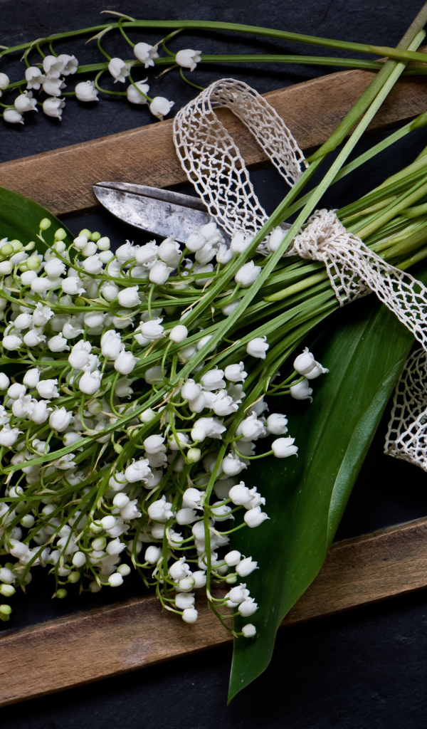 Букет белых ландышей с ножницами на столе