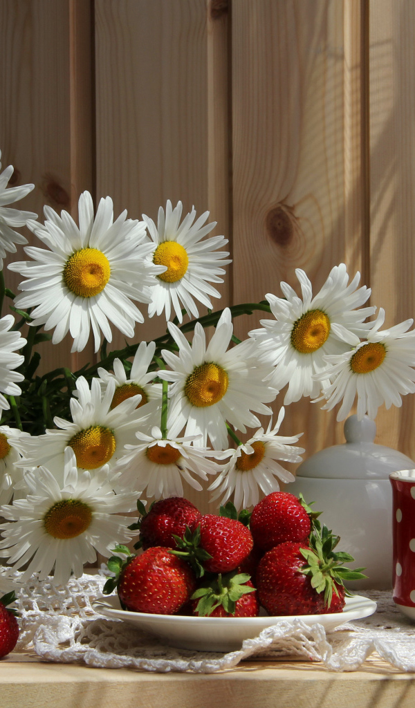 Букет белых ромашек на столе с клубникой