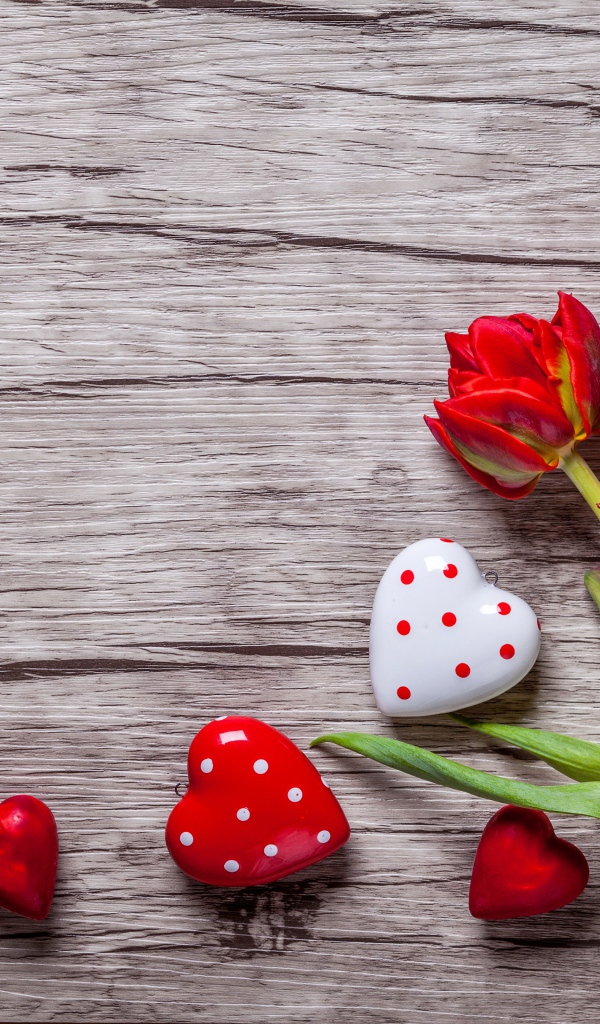 Красные красивые тюльпаны с сердечками на деревянной поверхности