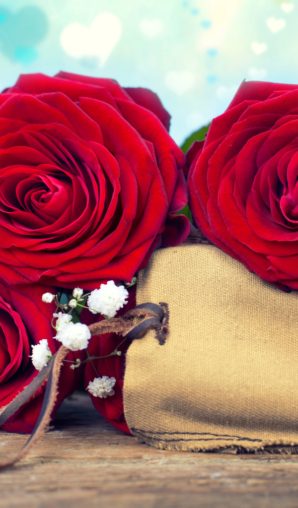 Три больших красных розы с тканевым мешочком