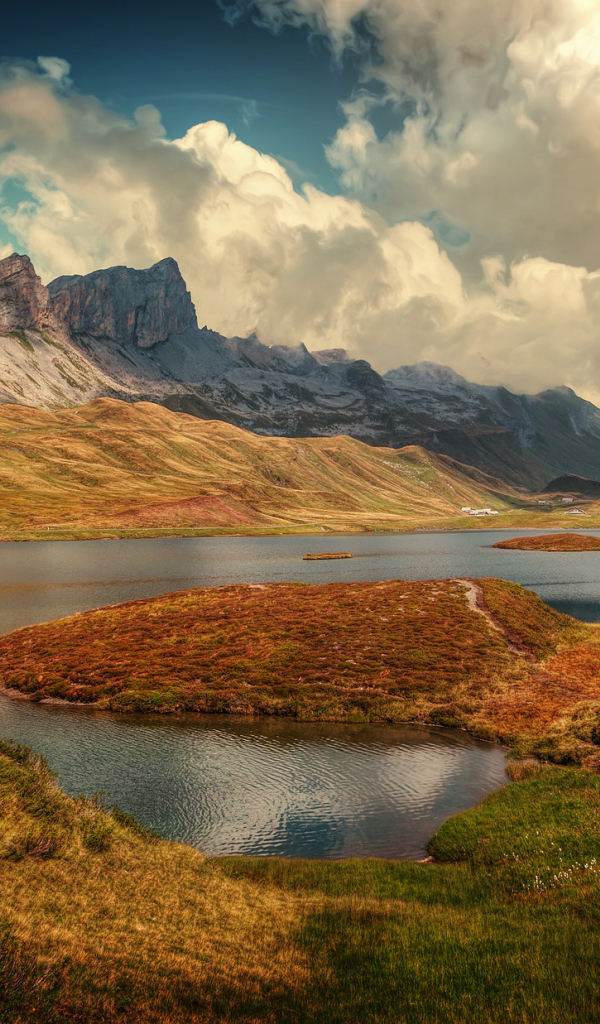 Горы под белыми облаками у озера в Швейцарии