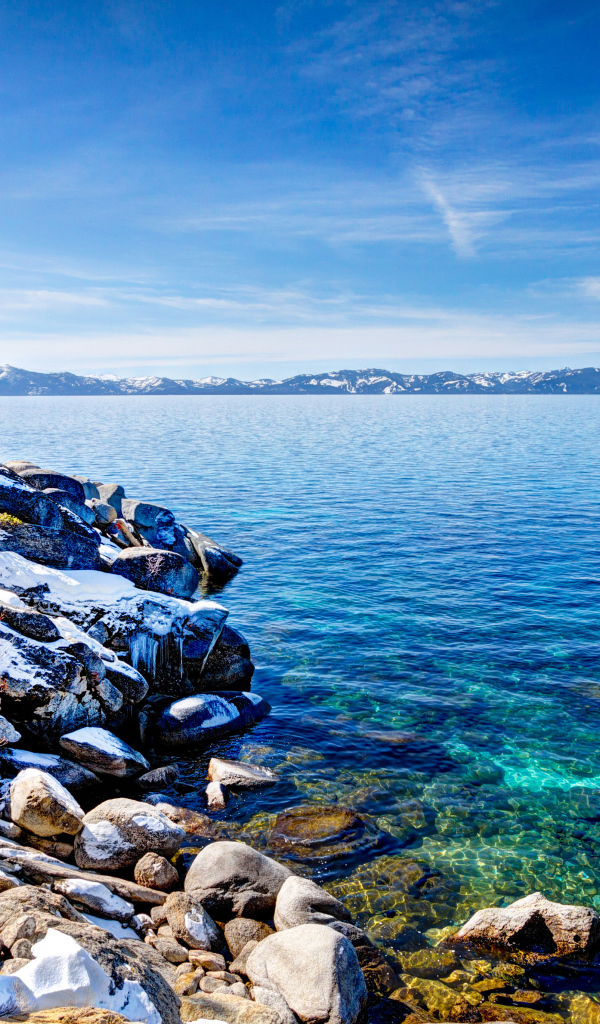 Чистая вода в озере Тахо с покрытыми снегом берегами, США