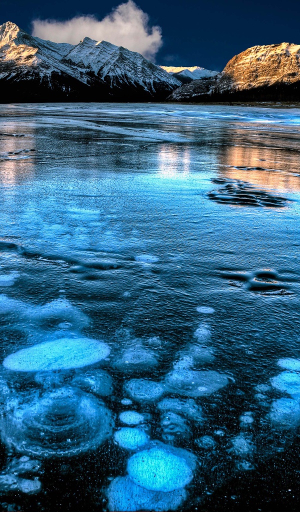 Покрытое льдом чистое  озеро Эйбрахам на фоне гор, Канада