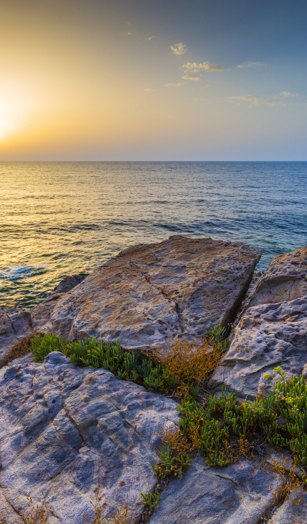 Каменные скалы на закате солнца над Средиземным морем, Греция
