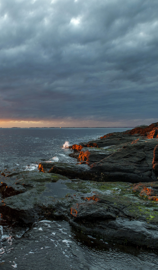 Каменное побережье в Норвегии на закате 