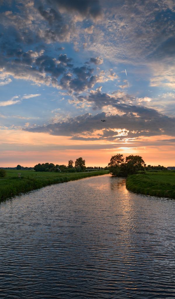 Закат солнца в облаках  над спокойной рекой