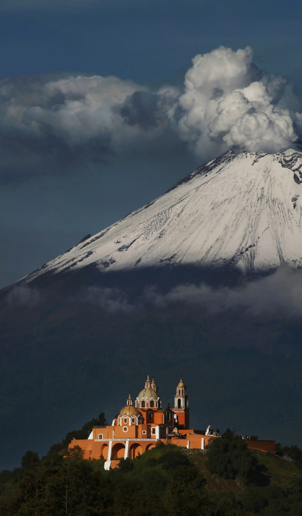 Дымящаяся вершина вулкана Попокатепетль в лучах солнца 