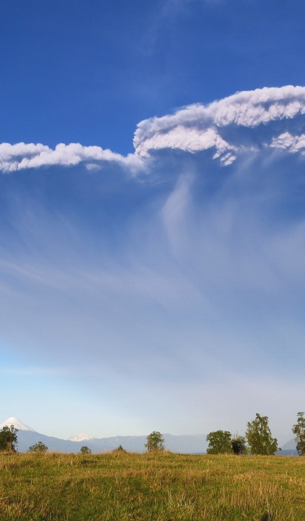 Белый дым активного вулкана Кальбуко в голубом небе, Чили