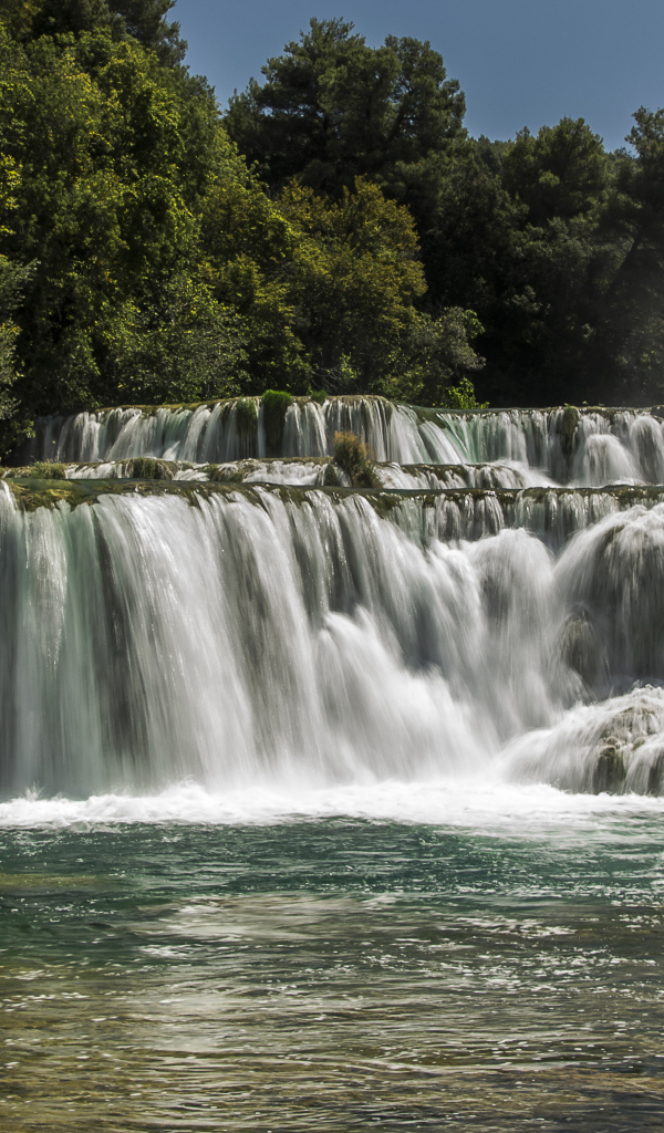 Быстрый водопад впадает в реку 