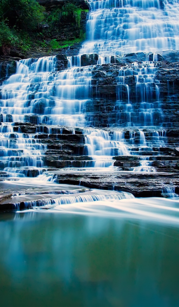 Водопад стекает по каменным порогам