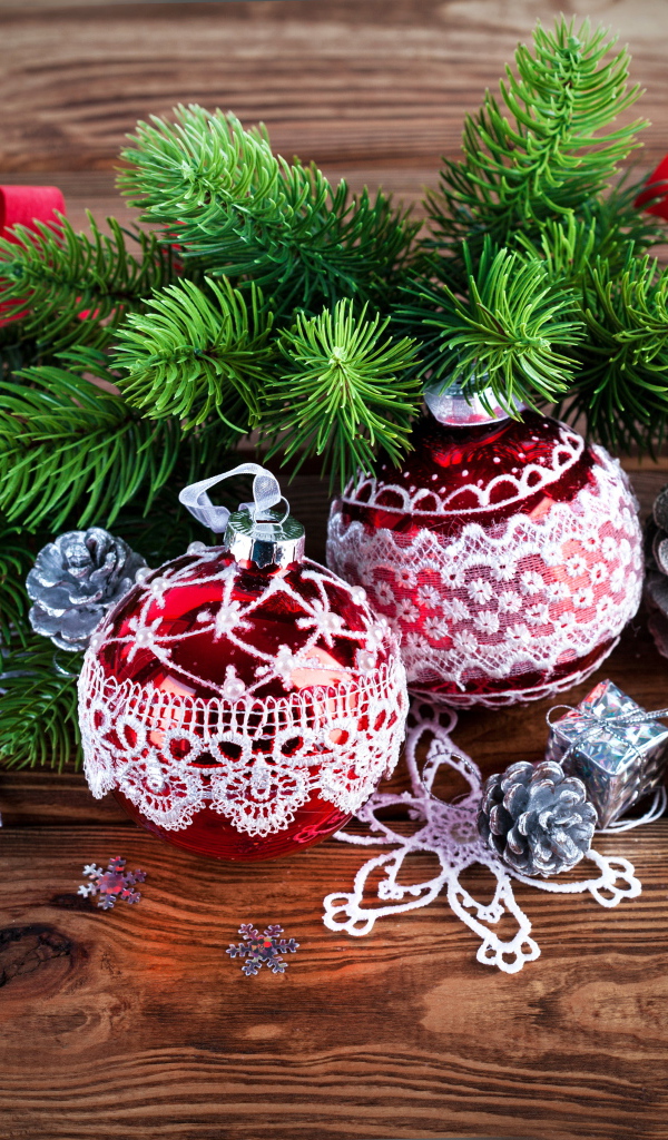 Красивые елочные игрушки с зеленой еловой веткой на деревянном столе 