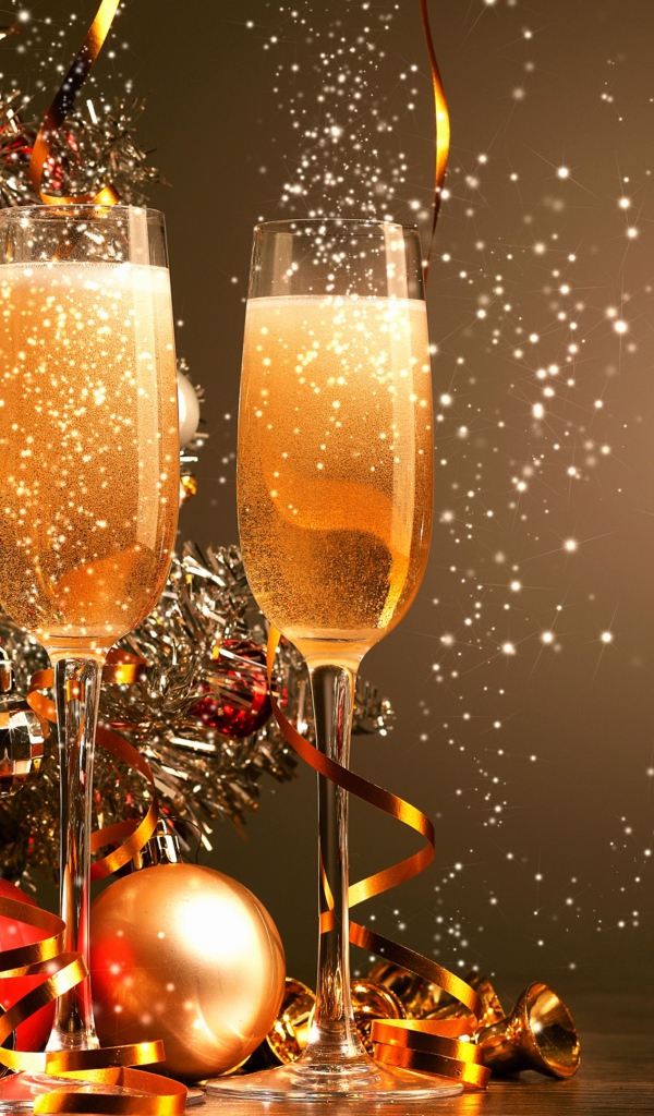 Два фужера с шампанским на фоне праздничной елки