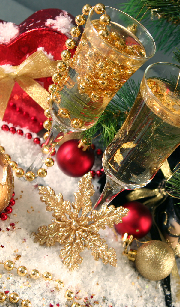 Два фужера с шампанский с новогодним декором под елкой