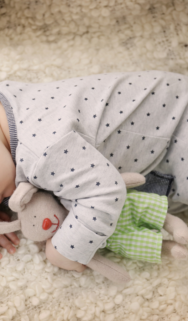 Грудной ребенок спит с любимой мягкой игрушкой