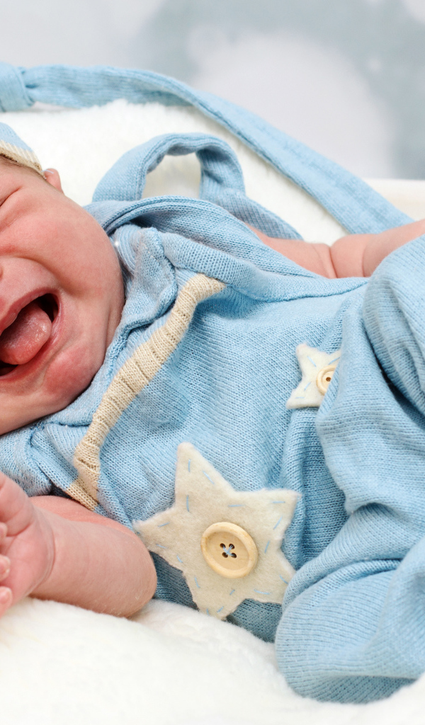 Плачущий младенец в голубом костюме