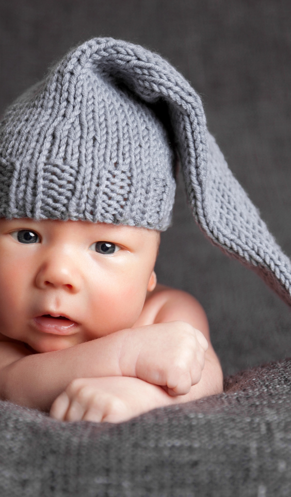 Милый младенец в большой серой вязаной шапке