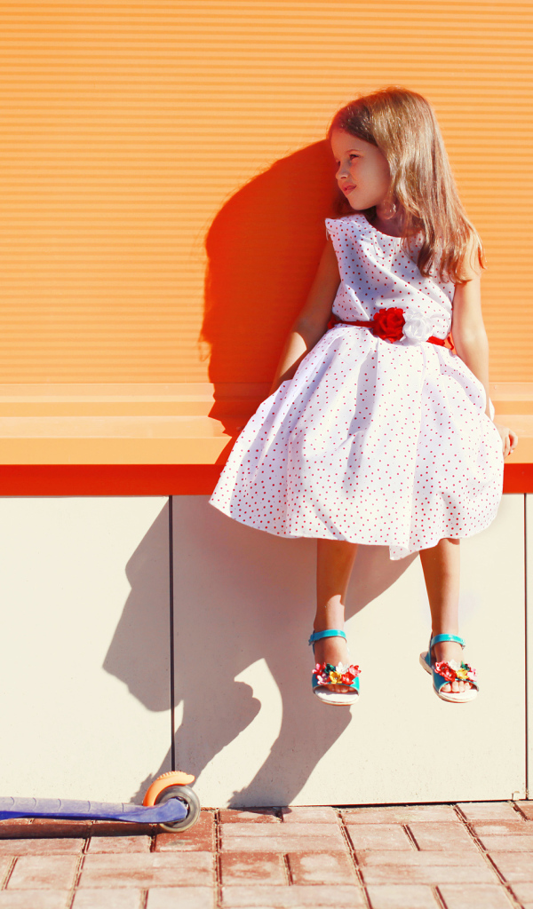 Девочка в красивом платье с самокатом