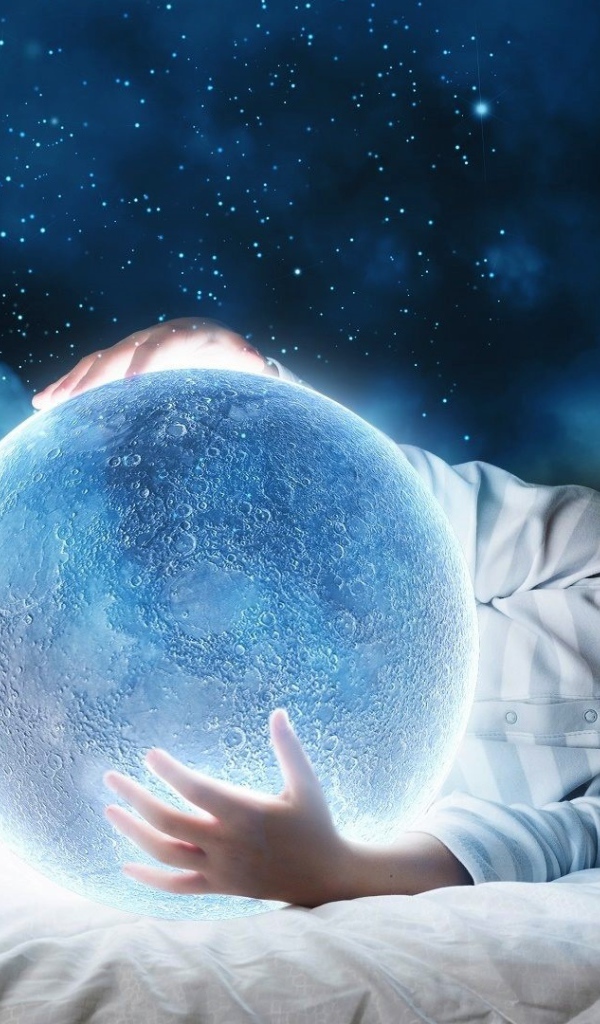 Маленький мальчик во сне держит в руках волшебную голубую луну