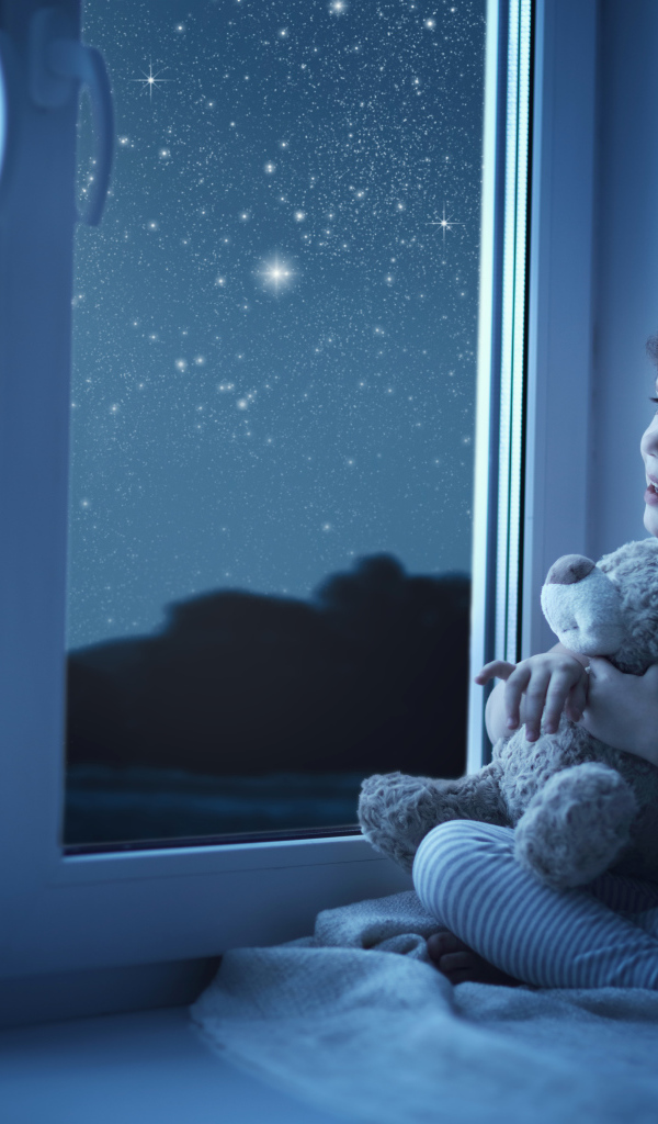 Маленькая девочка сидит на подоконнике с игрушкой ночью