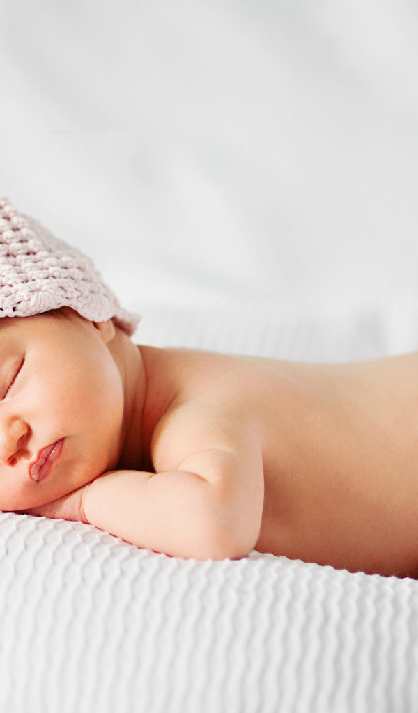 Спящий младенец девочка в розовой шапке