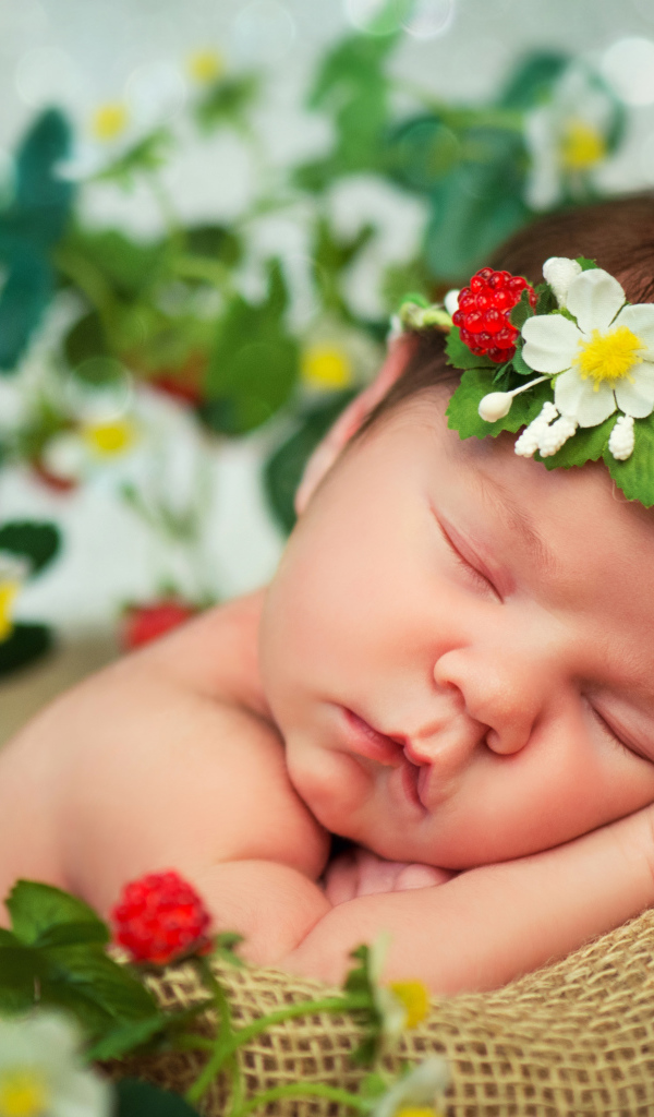 Спящий грудной ребенок с красивой повязкой на голове