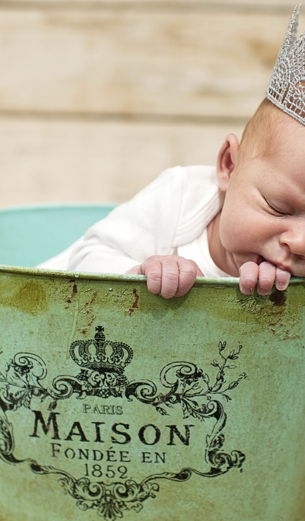 Спящий грудной ребенок с короной на голове