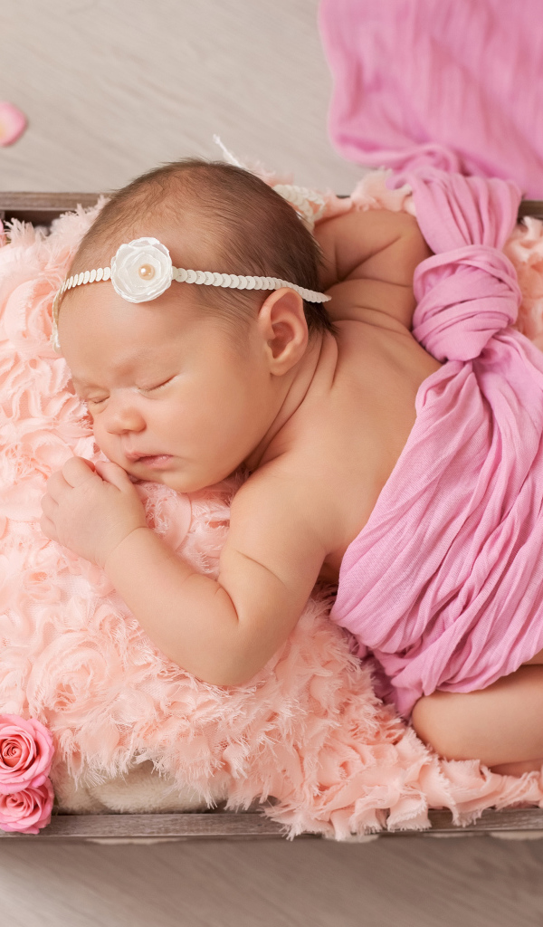 Спящий младенец с розовыми лепестками роз