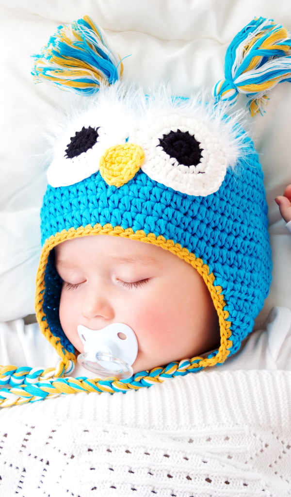 Спящий ребенок в забавной вязаной шапке