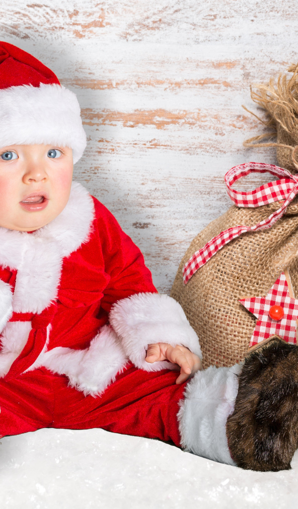 Маленький ребенок в костюме Санты с мешком