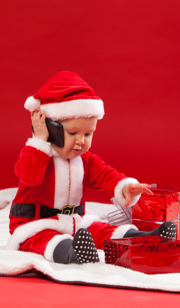 Маленький ребенок в новогодней униформе с подарками