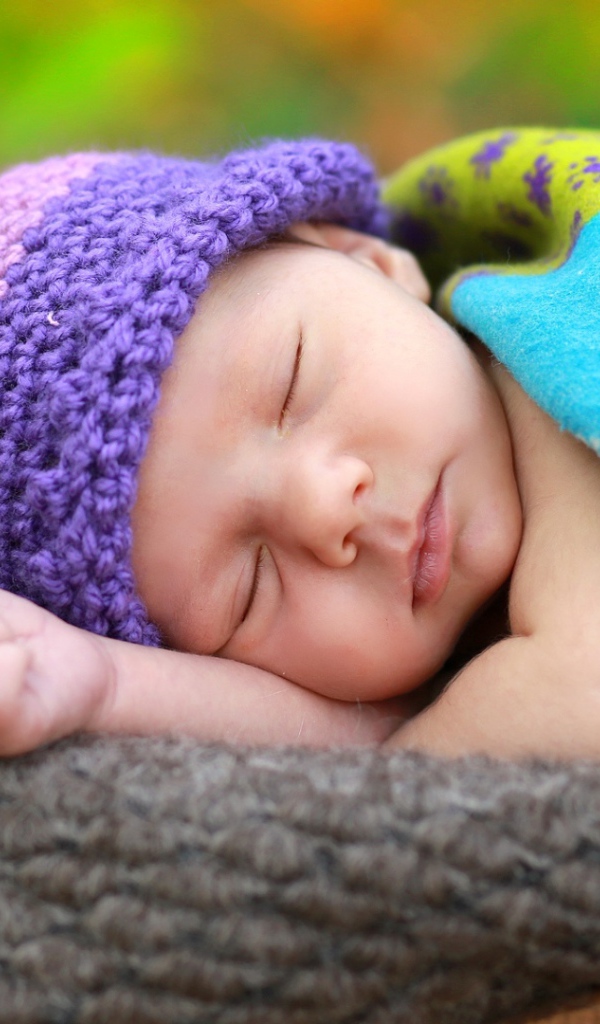 Маленький спящий младенец в вязаной шапке 