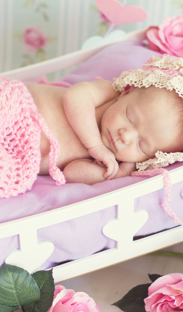 Милая спящая маленькая девочка в розовой кроватке