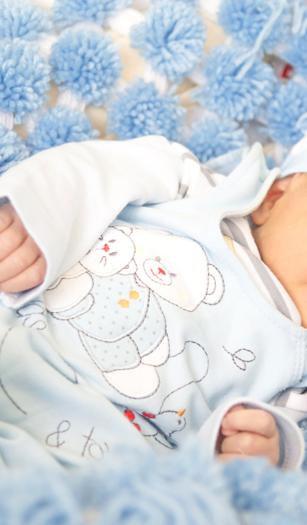 Младенец мальчик улыбается во сне