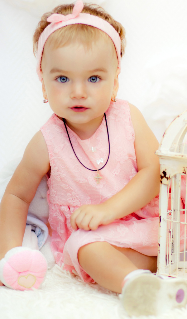 Красивая маленькая девочка в розовом платье с клеткой