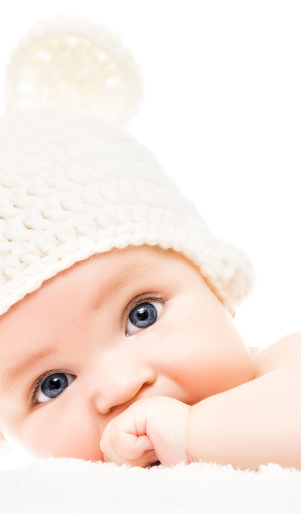 Голубоглазый младенец с белой шапке с ушками на белом фоне