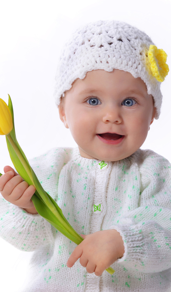 Голубоглазая маленькая девочка с желтым тюльпаном в руках