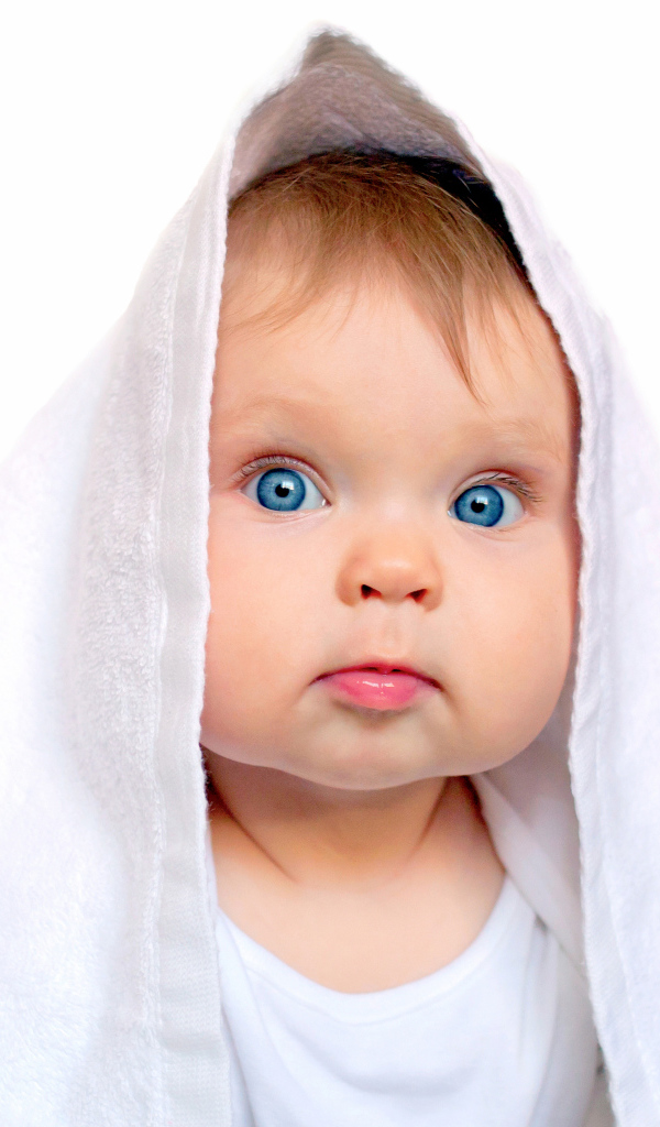 Милый голубоглазый малыш с белом полотенце