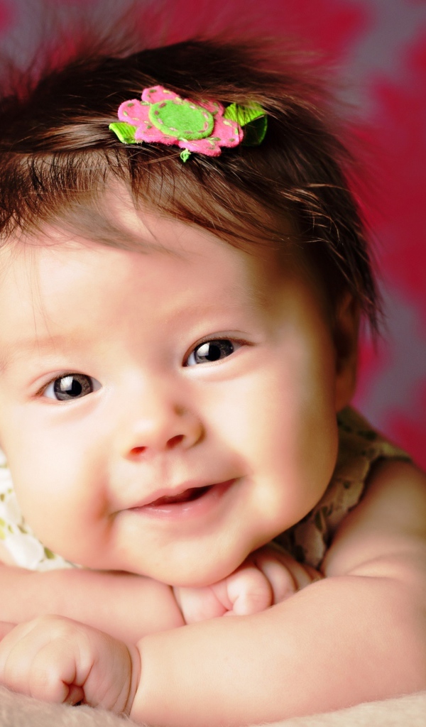 Милая маленькая девочка с цветком в волосах 