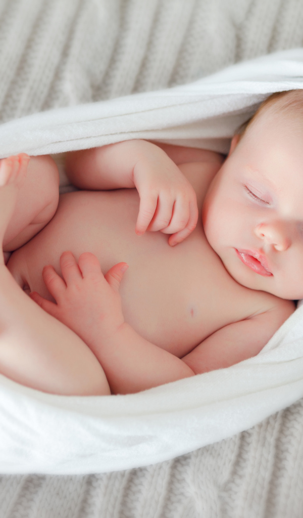 Милый спящий младенец в белом покрывале