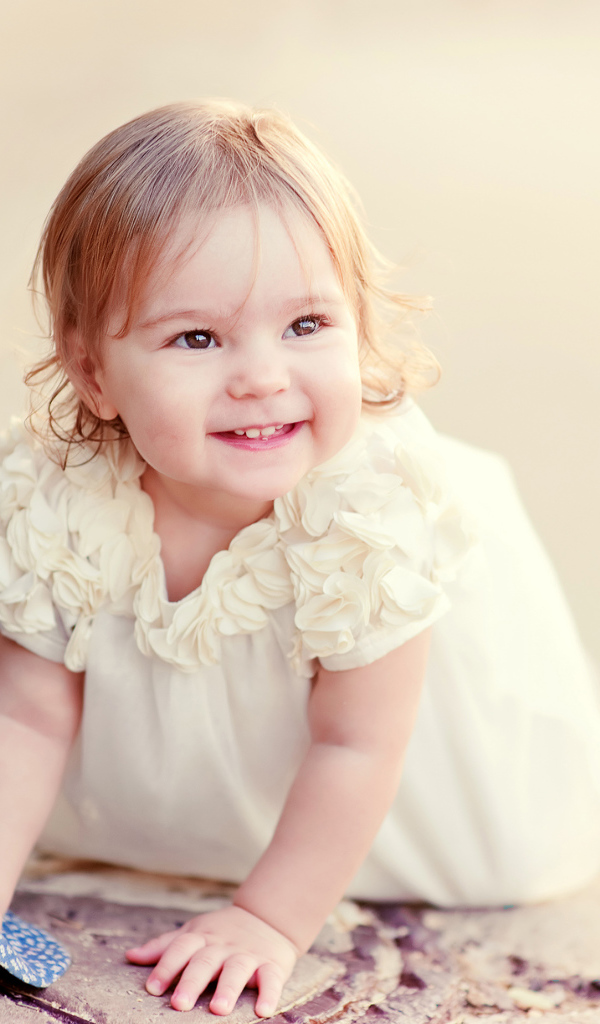 Милая улыбающаяся девочка в белом платье