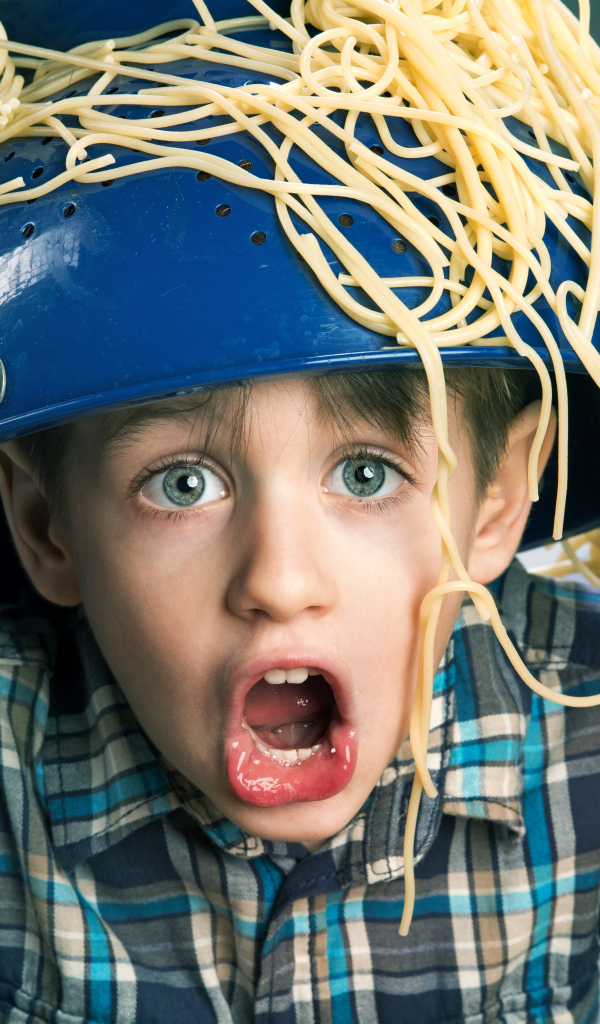 Смешной мальчик со спагетти на голове