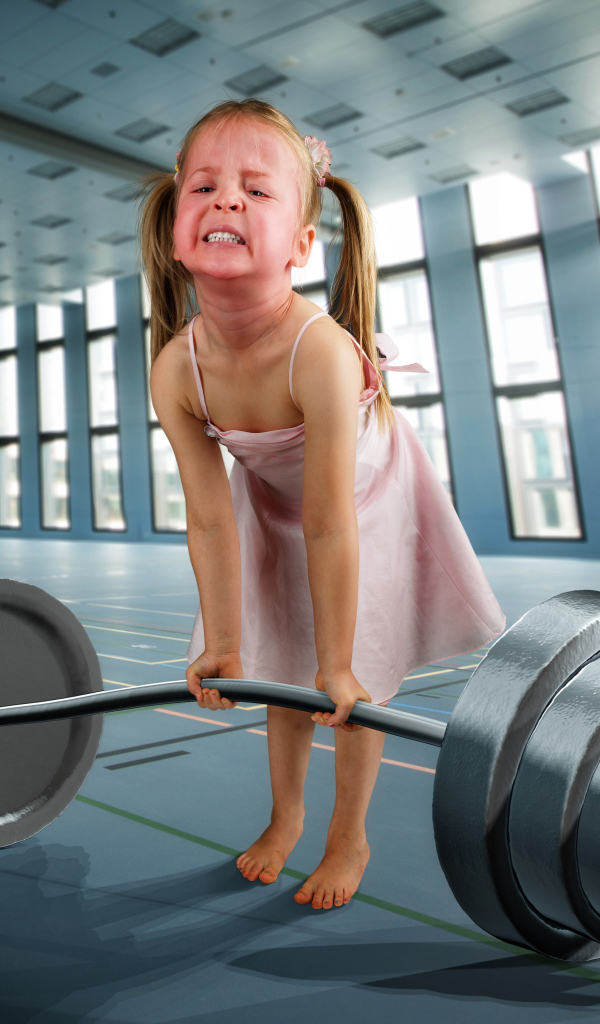 Смешная девочка пытается поднять тяжелую штангу