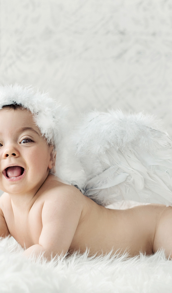 Забавный улыбающийся ребенок с крыльями ангела