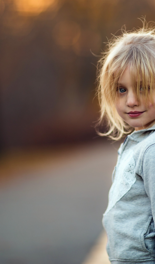 Маленькая девочка блондинка в серой кофте