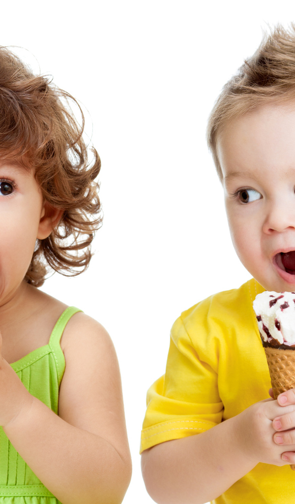 Маленькие мальчик и девочка едят вкусное мороженое