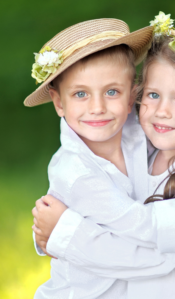 Маленькие мальчик и девочка обнимают друг друга