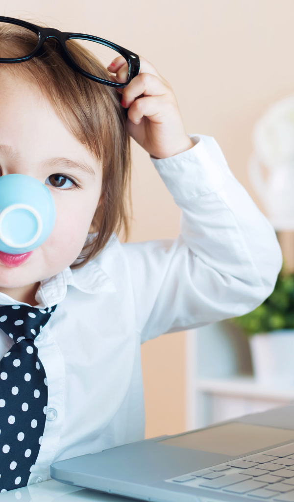 Маленький мальчик в деловом костюме и с чашкой