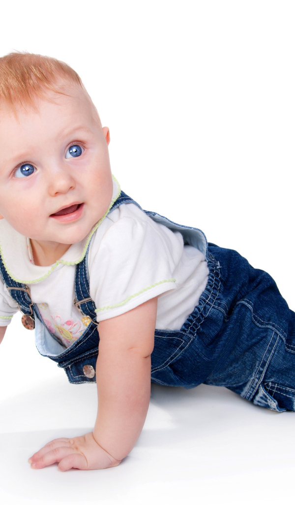 Маленький мальчик в синем комбинезоне на белом фоне